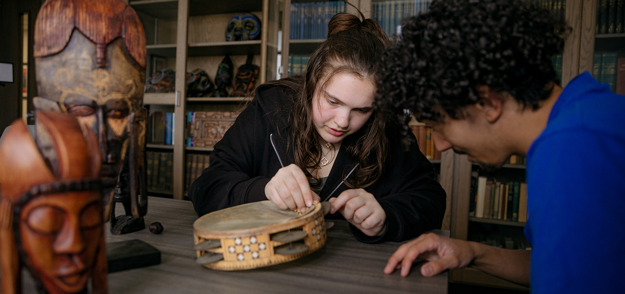 Two students looking over materials in a classroom